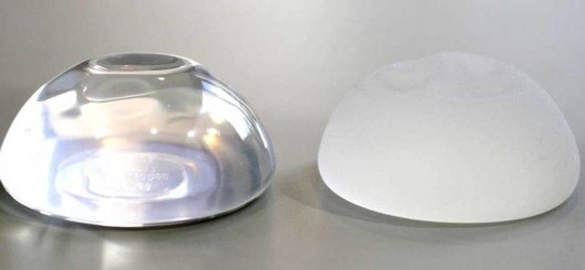 Saline and silicon breast implants on the grey background