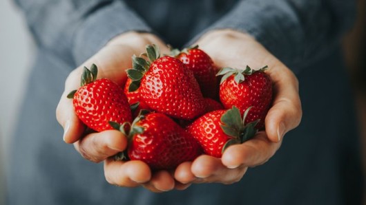 A close up strawberries in man't hands