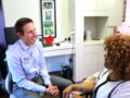 A guy in blue shirt is talking to a dentist about the dental care