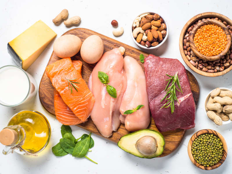 Lean protein: chicken, beaf, salmon, nuts, avocado, lentils, eggs on wooden cutting board and white background