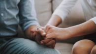 A girl is holding a man's hand to help him cope with grief