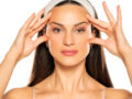 A beautiful girl on white background touching her face with fingers