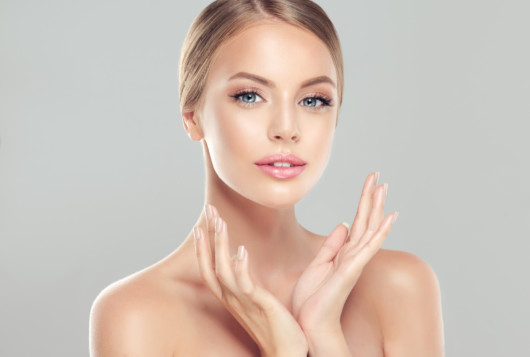 A close up picture of a beautiful young girl with perfect skin on white background