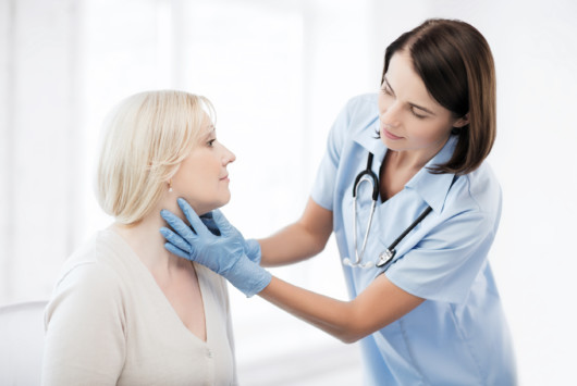 A woman doctor is checking woman's throat in a walk-in clinic