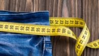 jeans with a tape measure on wooden background