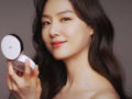 A close up picture of a beautiful Korean girl with a perfect skin on dark background who looks into the mirror
