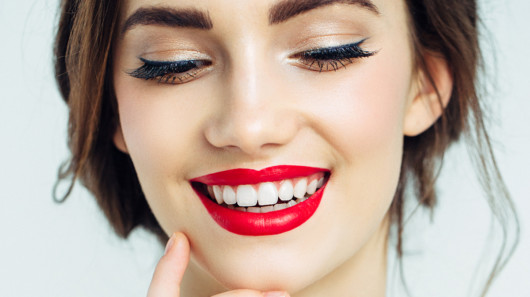 A close up picture of a beautiful girl with red lips and white perfect teeth 