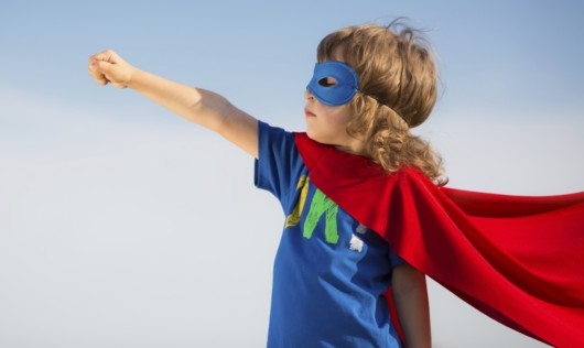 A small boy dressed as a superman