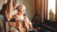 A young lady is taking care of an old woman in a hospice