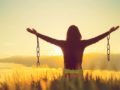 A young girl is staying with her arms spread to the sites welcoming the sunrise