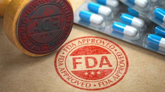 blue and white pills and red FDA stamp on the brown background 