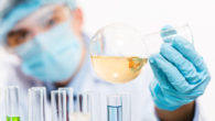 laboratory assistant is holding test tube with a liquid and checking it