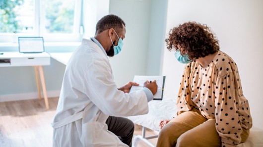 A doctor and a woman are in discussing the cosmetic procedure