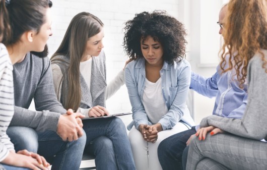 A group of people in rehabilitation center who support a young addict girl