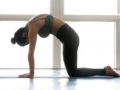 The girl is doing cat cow pose to get rid of the back pain. Top stretch poses to ease back pain