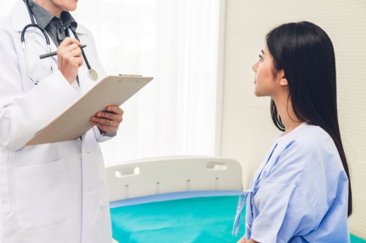 A girl is talking to the doctor before the cosmetic operation