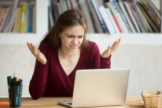 Girl is sitting in front of the laptop and doesn't know what to write