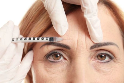 A middle age woman with face wrinkles is doing botox treatment