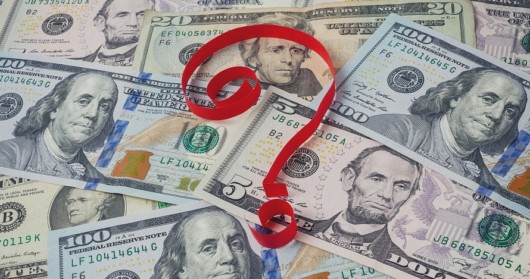 A red question mark on top dollar banknotes