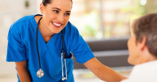 A smiling doctor is talking kindly to a elderly woman