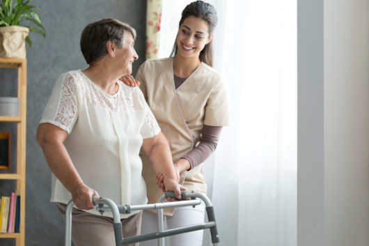 a nurse is helping an old woman to walk