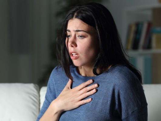 A worried girl holding her hand on the chest showing her anxiety