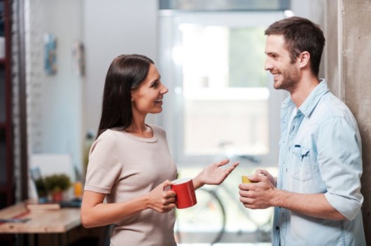 A girl with a red cup is talking happily to a guy