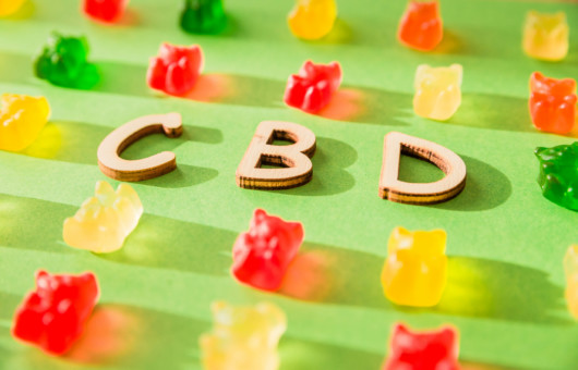 CBD on a green background and gelatin in the form of bears.