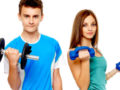 Teenage girl and a boy on the white background holding dumbbells