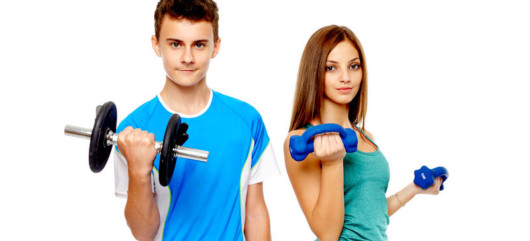 Teenage girl and a boy on the white background holding dumbbells