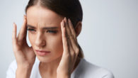 Girl is keeping her fingers at the temples due to a severe headache