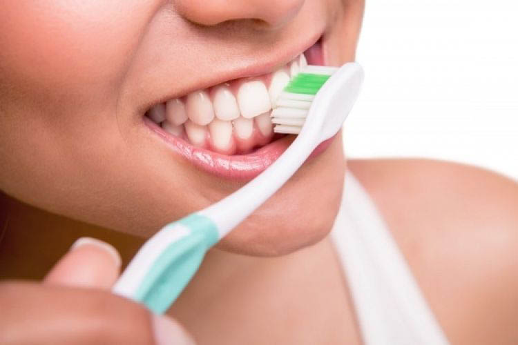 Close up picture of the girl who is brushing her teeth