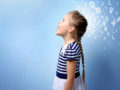 a little girl in a blue stripped dress is standing with her mouth open on the blue background with white letters behind her