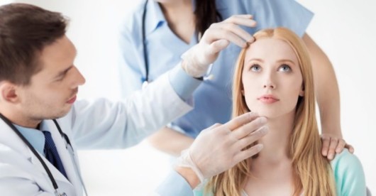 A plastic surgeon is checking the girl's face