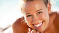 A young and beautiful girl smiling and showing her even and white teeth after cosmetic dentistry