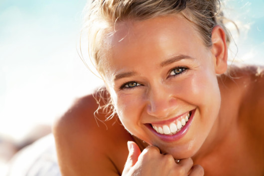 A young and beautiful girl smiling and showing her even and white teeth after cosmetic dentistry