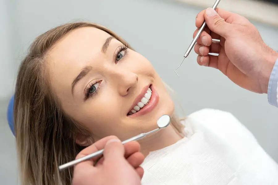A girl is doing check up of her teeth after cosmetic dentistry