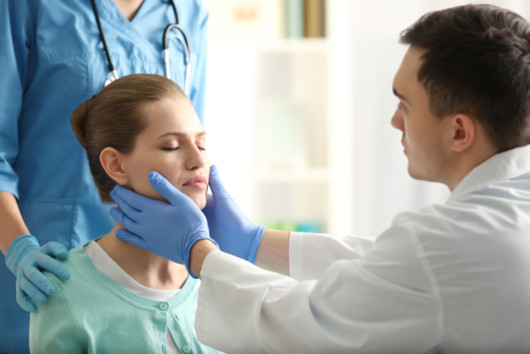 A doctor is examining the young girl's face before the plastic surgery procedure