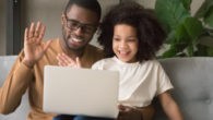 black dad with kid daughter. They are doing speech teletherapy