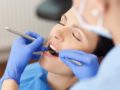 The woman is under dental sedation while the doctor is checking her teeth