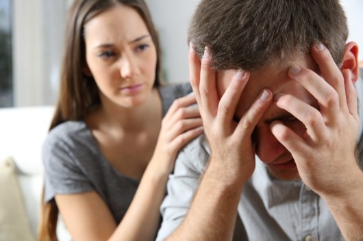 The girl is trying to calm down the man who is having panic attack