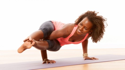 A black woman is strengthening her body with yoga.