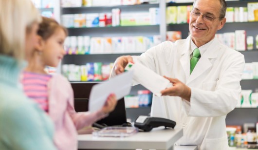 A pharmacist is talking to the customers in the pharmacy