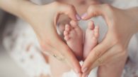 A close up picture of a baby feet in heart made hands