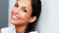 A close up fave of a beautiful woman with dark hair who is smiling on white background