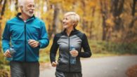 A senior couple is exercising in the park in autumn