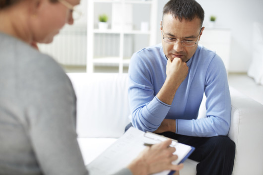 A guy is talking to a doctor at the rehab