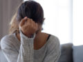 A young woman is sad sitting with her had down