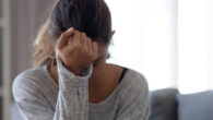 A young woman is sad sitting with her had down