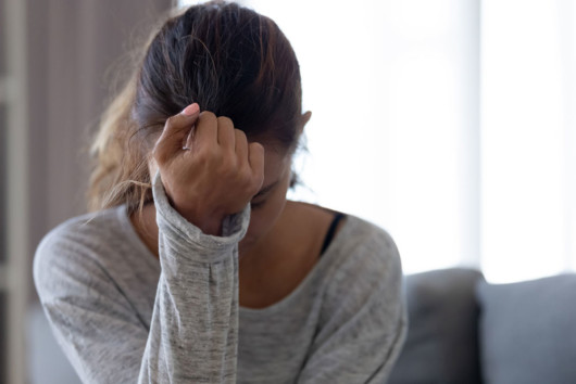 A young woman is sad sitting with her had down